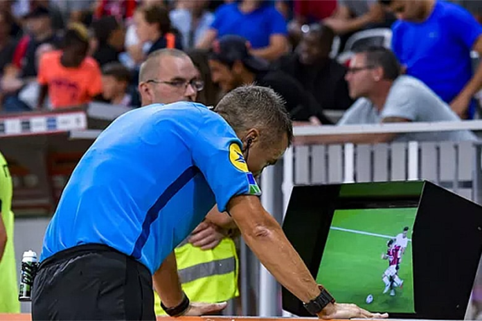 Football referee checking VAR screen during a professional match