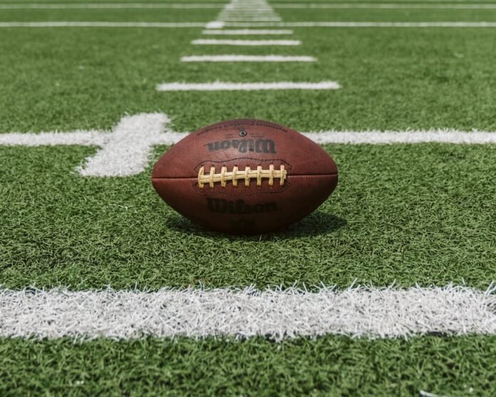 Football beside a laptop displaying a sportsbook website and licence verification checklist